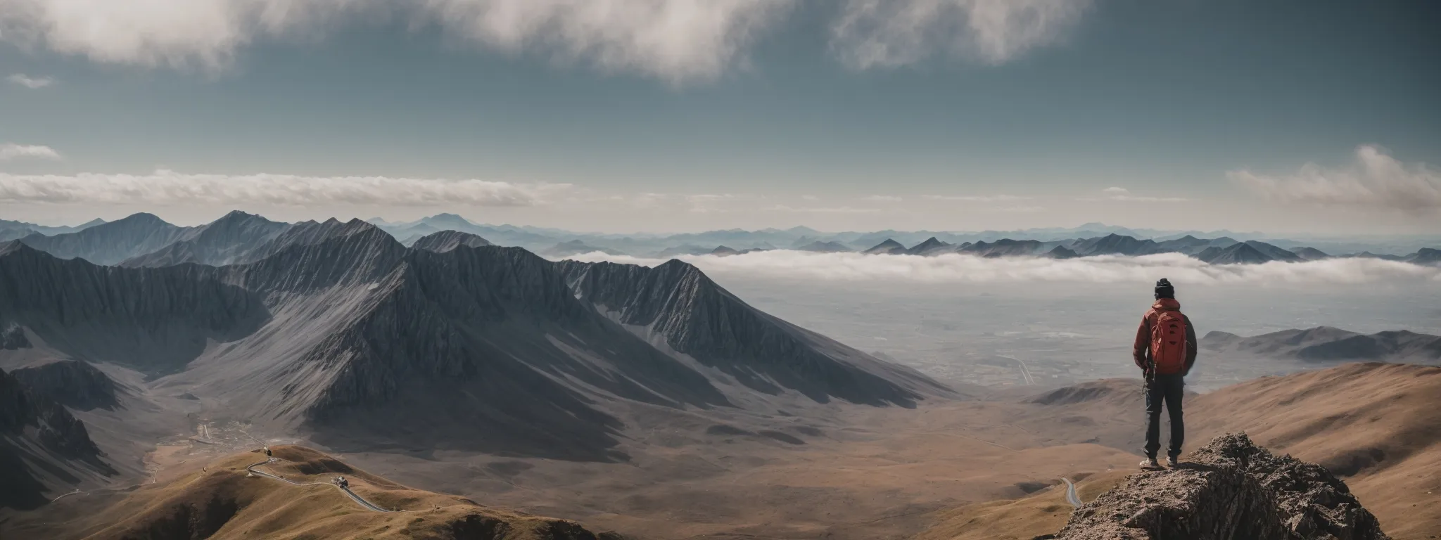 a person on a mountaintop, gazing at the horizon, symbolizes the broad vision and high aspirations seo professionals have when leveraging searchatlas tools.