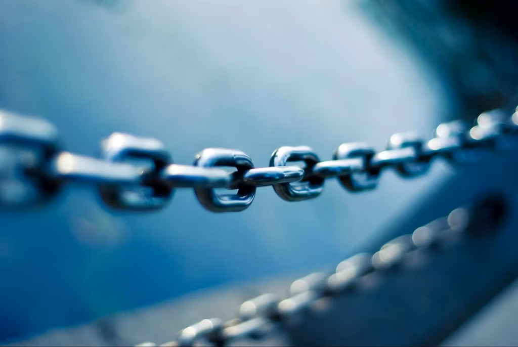 Close-up image of a metal chain in focus with a blurred blue-toned background, symbolizing connection, strength, or linking concepts such as backlinks in SEO